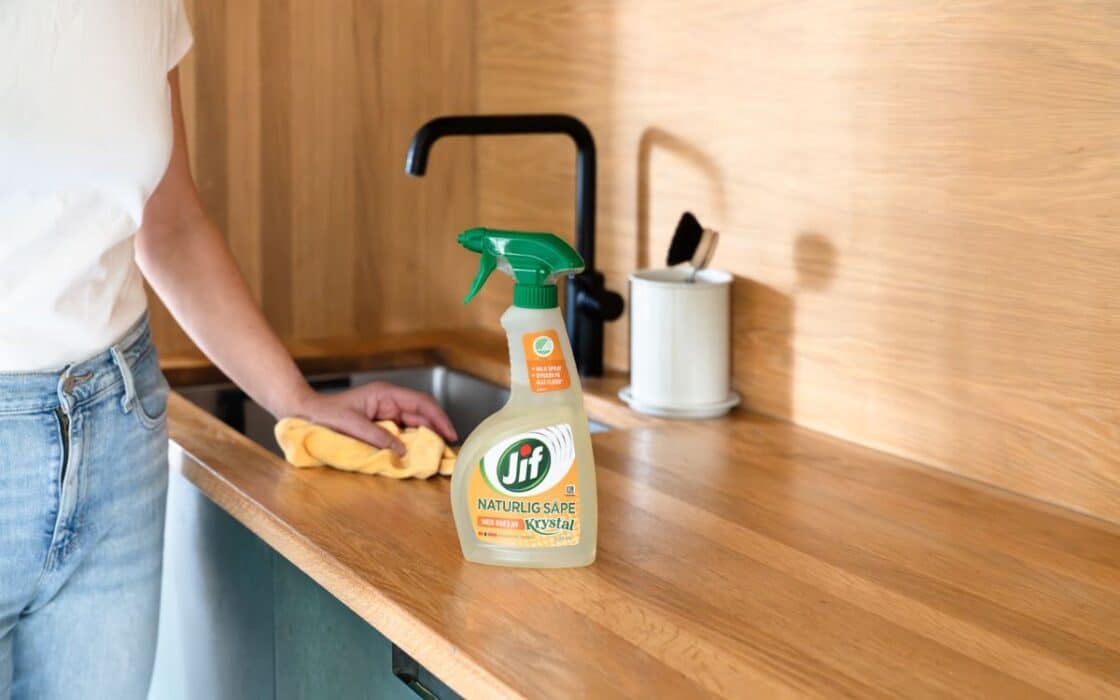 Kvinne vasker med Jif Naturlig Såpe Spray.